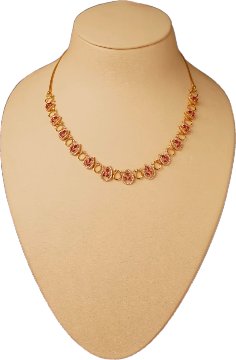 Gold necklace with ruby and diamond-set paisley links on a cream display bust